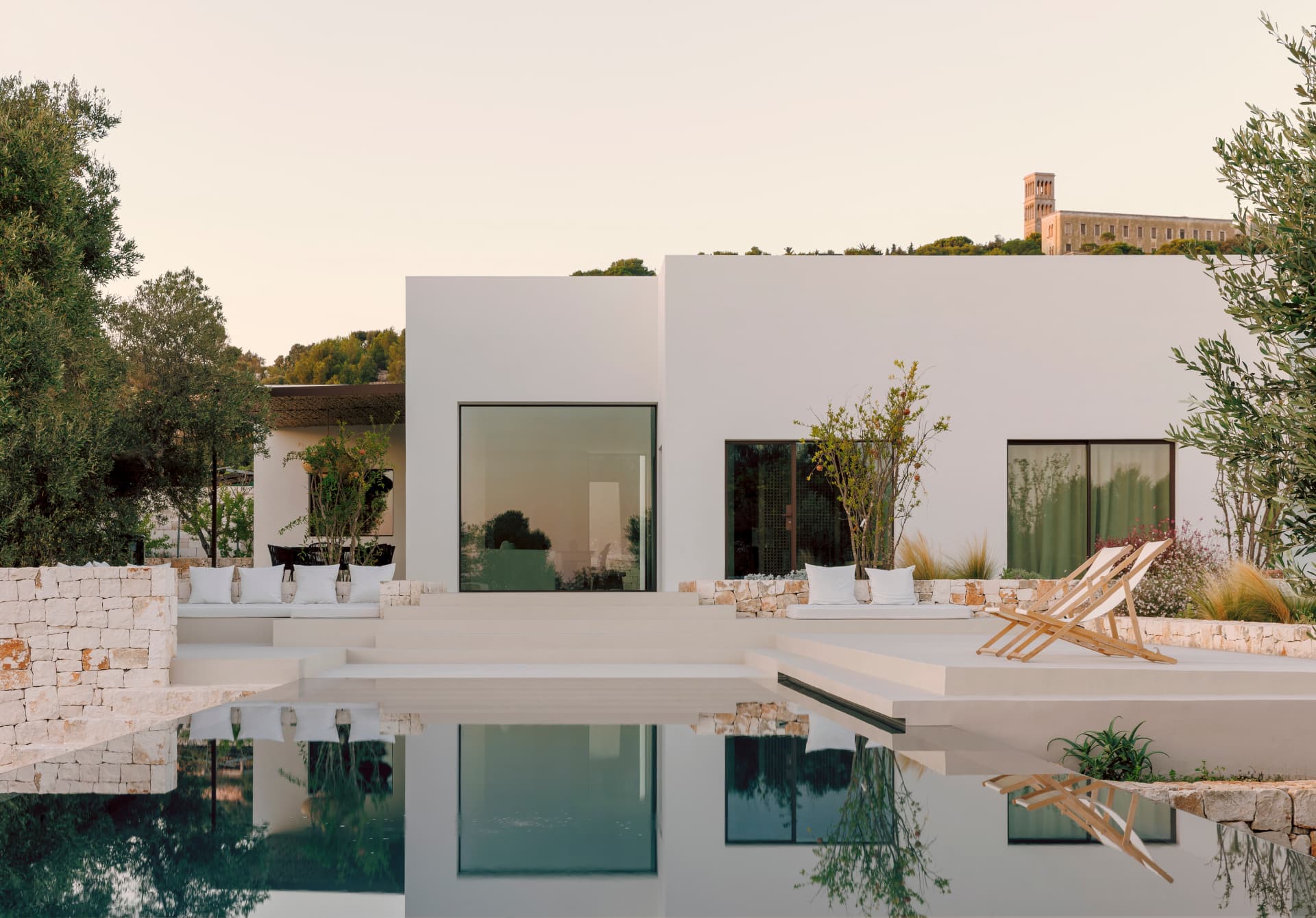 Villa Volontè: facciata minimal con grandi vetrate in acciaio e piscina a sfioro