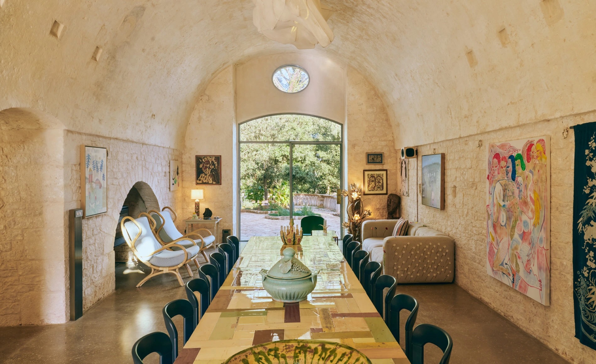 Sala voltata in pietra di masseria pugliese con grande vetrata ad arco in acciaio